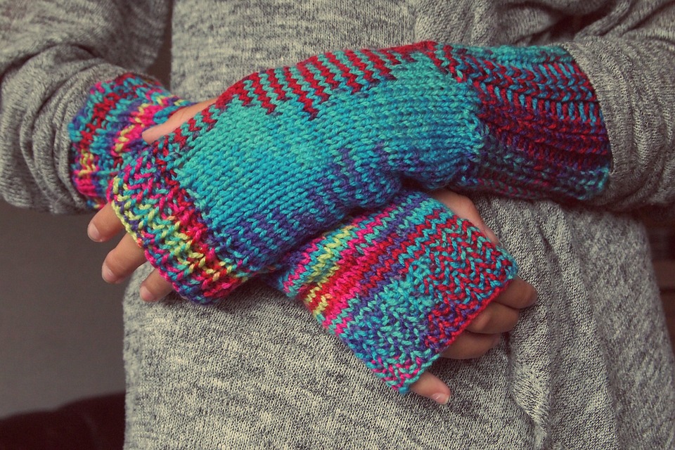 hænder med strikkede handsker