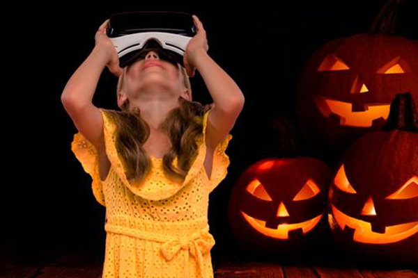 Pige med VR briller og lysende græskar i baggrunden